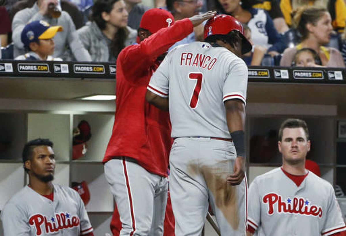 Philadelphia Phillies' Maikel Franco is greeted at the dugout after scoring against the San Diego Padres on a hit by Cameron Rupp during the sixth inning of a baseball game Friday, Aug. 5, 2016, in San Diego. (AP Photo/Lenny Ignelzi)