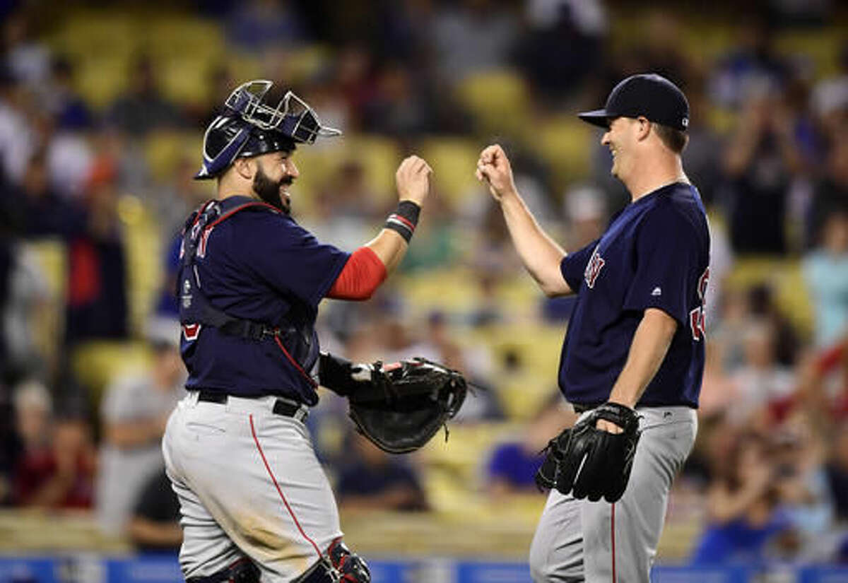 Boston Red Sox catcher Sandy Leon, left, congratulates starting pitcher Steven Wright after the Red Sox defeated the Los Angeles Dodgers 9-0 in a baseball game, Friday, Aug. 5, 2016, in Los Angeles. (AP Photo/Mark J. Terrill)