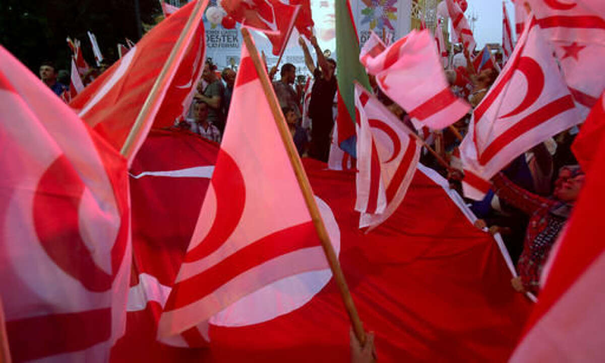 Turkish Cypriot demonstrators wave Turkish and Turkish Cypriot flags during a mass rally in support of Turkey's Prime Minister Recep Tayyip Erodgan following a failed coup in Turkey, in the breakaway Turkish Cypriot half of the capital Nicosia on Friday, Aug. 5, 2016. Mostly right-wing political parties and groups urged supporters to turn up for the rally.(AP Photo/Philippos Christou)