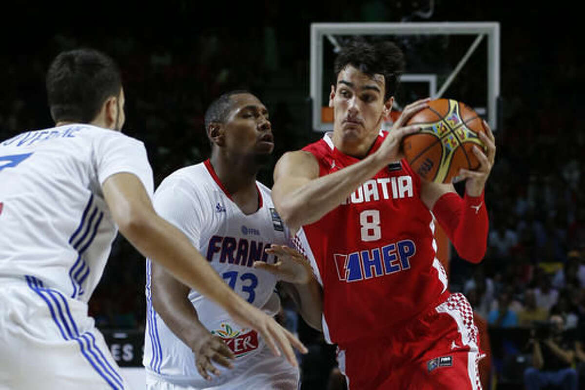 FILE - In this Sept. 6, 2014, file photo, Croatia's Dario Saric, right, drives the ball against France's Boris Diaw, center, and Joffrey Lauvergne during the World Cup Round of 16 match between Croatia and France in Madrid, Spain. From Kyrie to KD, DeMar to DeMarcus, the players on the U.S. basketball team are so well known that they can simply go by nicknames or first names. But there are plenty more players who either are, or soon might be, familiar to NBA fans watching the Olympics. Here’s a look at a few of them, players like Dario Saric (Croatia), Willy Hernangomez (Spain) and Yi Jianlian (China), as competition begins Saturday. (AP Photo/Daniel Ochoa de Olza, File)