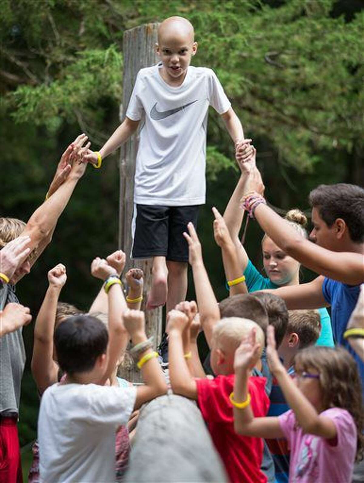 FOR RELEASE SATURDAY, AUGUST 6, 2016, AT 12:01 A.M. CDT.- Aiden Solon walks a balance beam with the help of other campers during camp CoHoLo held at the Eastern Nebraska 4-H Center Monday, July 25, 2016, in Gretna, Neb. (Matt Dixon/The World-Herald via AP)