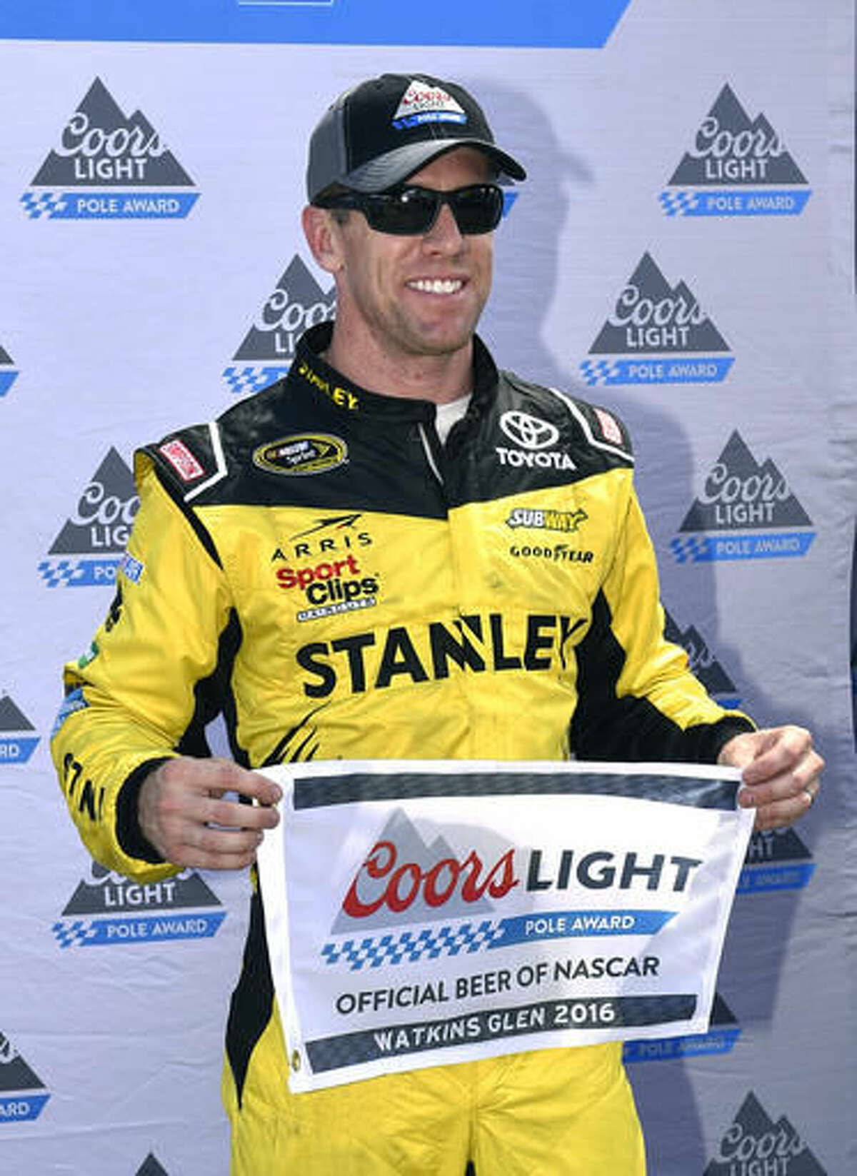 Carl Edwards poses with the pole award after qualifying for Sunday's NASCAR Sprint Cup series auto race at Watkins Glen International, Saturday, Aug. 6, 2016, in Watkins Glen, N.Y. (AP Photo/Derik Hamilton)
