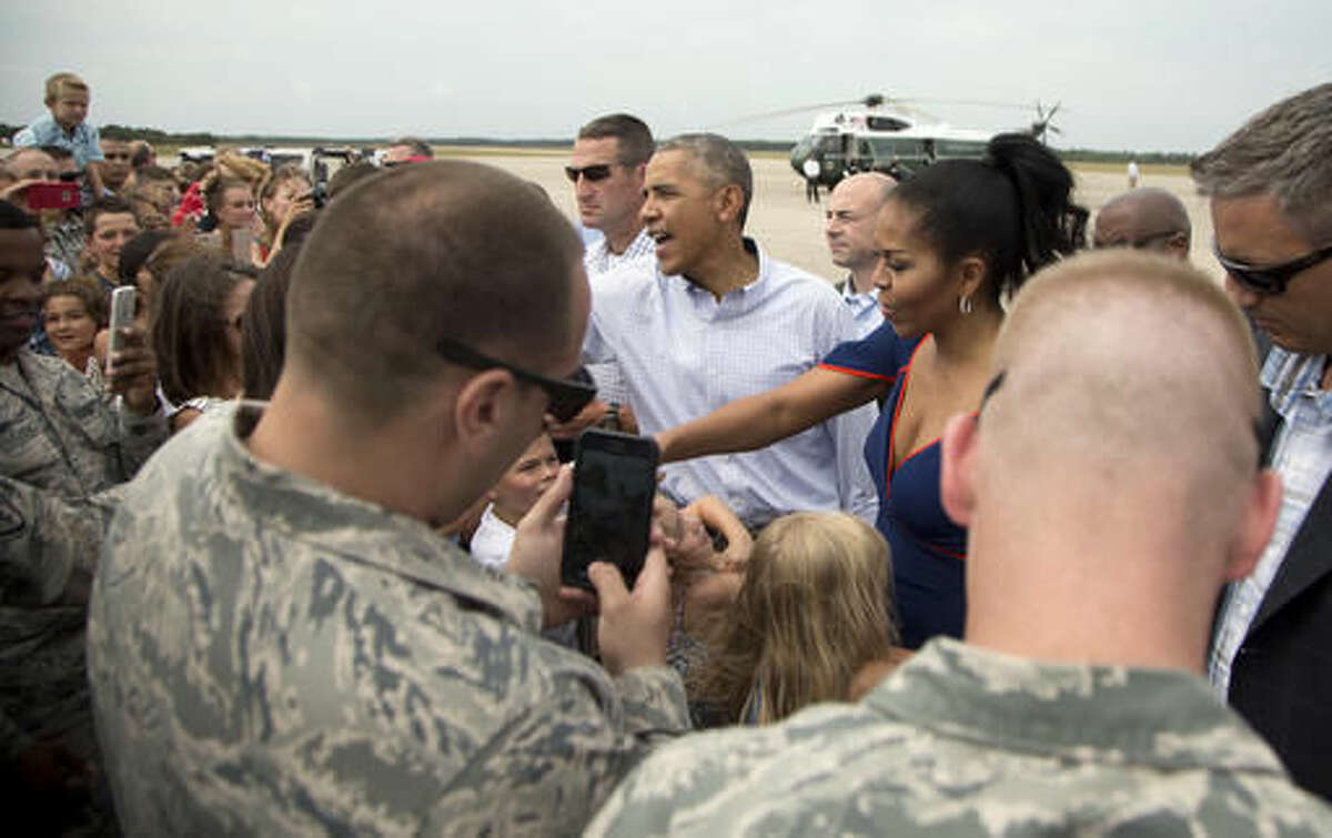 President Barack Obama and first lady Michelle Obama greet members of the military and their family as they arrive at Air Station Cape Cod, in Mass., Saturday, Aug. 6, 2016. The president and his family are vacationing in the Massachusetts island of Martha's Vineyard. (AP Photo/Manuel Balce Ceneta)