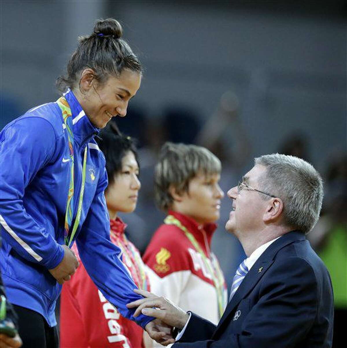 La judoca Majlinda Kelmendi, de Kosovo, dialoga con el presidente del COI, Thomas Bach, tras recibir la medalla de oro en la competencia de -52 kilogramos en los Juegos Olímpicos de Río de Janeiro, Brasil, el domingo 7 de agosto de 2016. (AP Foto/Charlie Riedel)