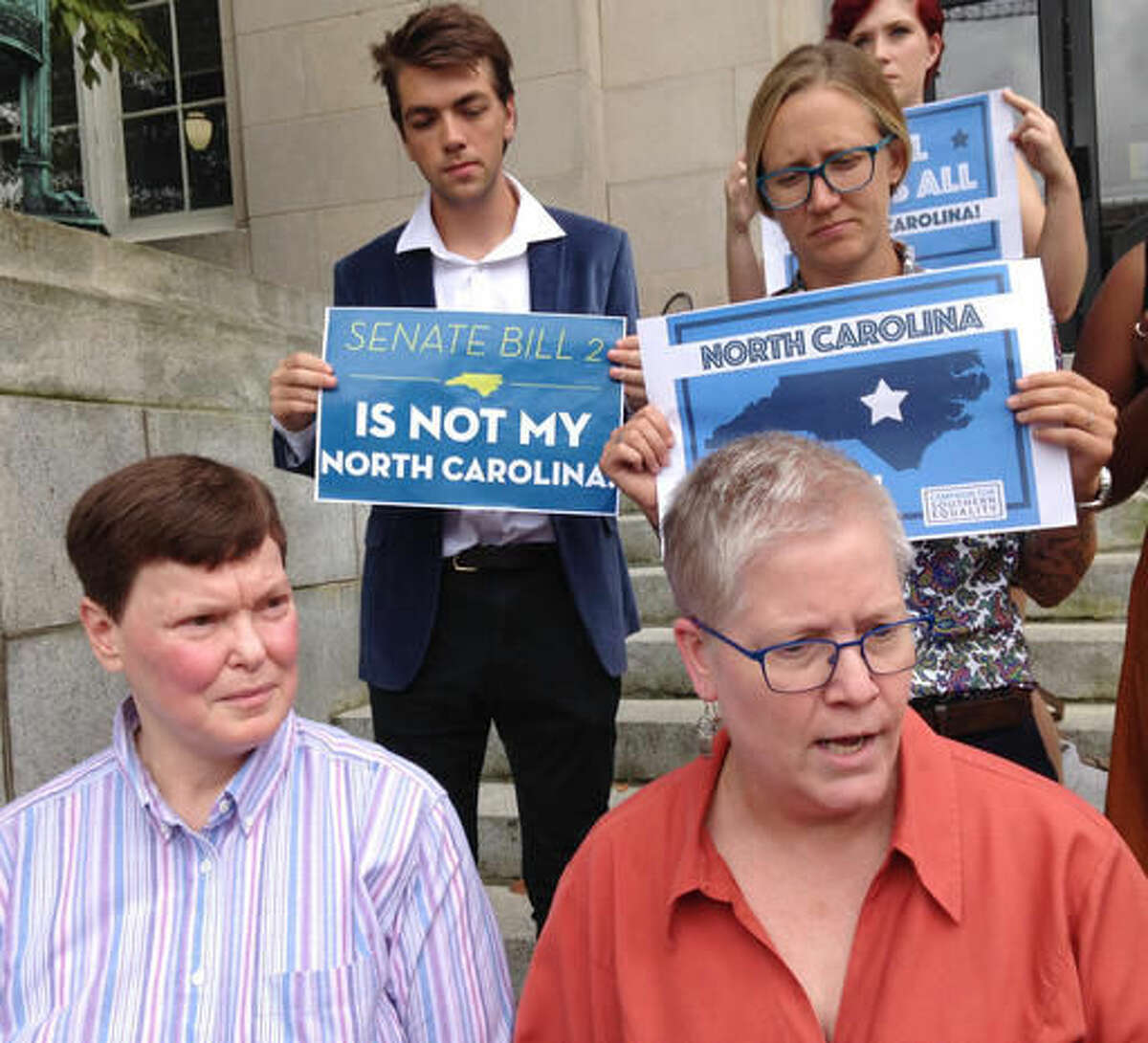 Diane Ansley, left and her spouse, Cathy McGaughey, right, talk about their challenge to North Carolina's law allowing magistrates to opt out of performing gay marriages for religious reasons outside the federal courthouse in Asheville, N.C. on Monday, Aug. 8, 2016. (AP Photo/Jeffrey Collins)