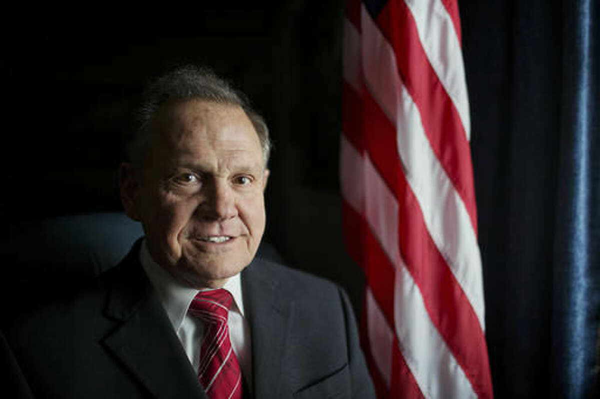 FILE - In this Feb. 17, 2015, file photo, Alabama Chief Justice Roy Moore poses in front the the American flag in Montgomery, Ala. Moore has been suspended from office after the Judicial Inquiry Commission accused him of violating the canons of judicial ethics with his actions during the fight over same-sex marriage. Moore will attend a hearing Monday, Aug. 8, 2016 that will determine the course of the judicial ethics case against the suspended Alabama Chief Justice. (AP Photo/Brynn Anderson, File)