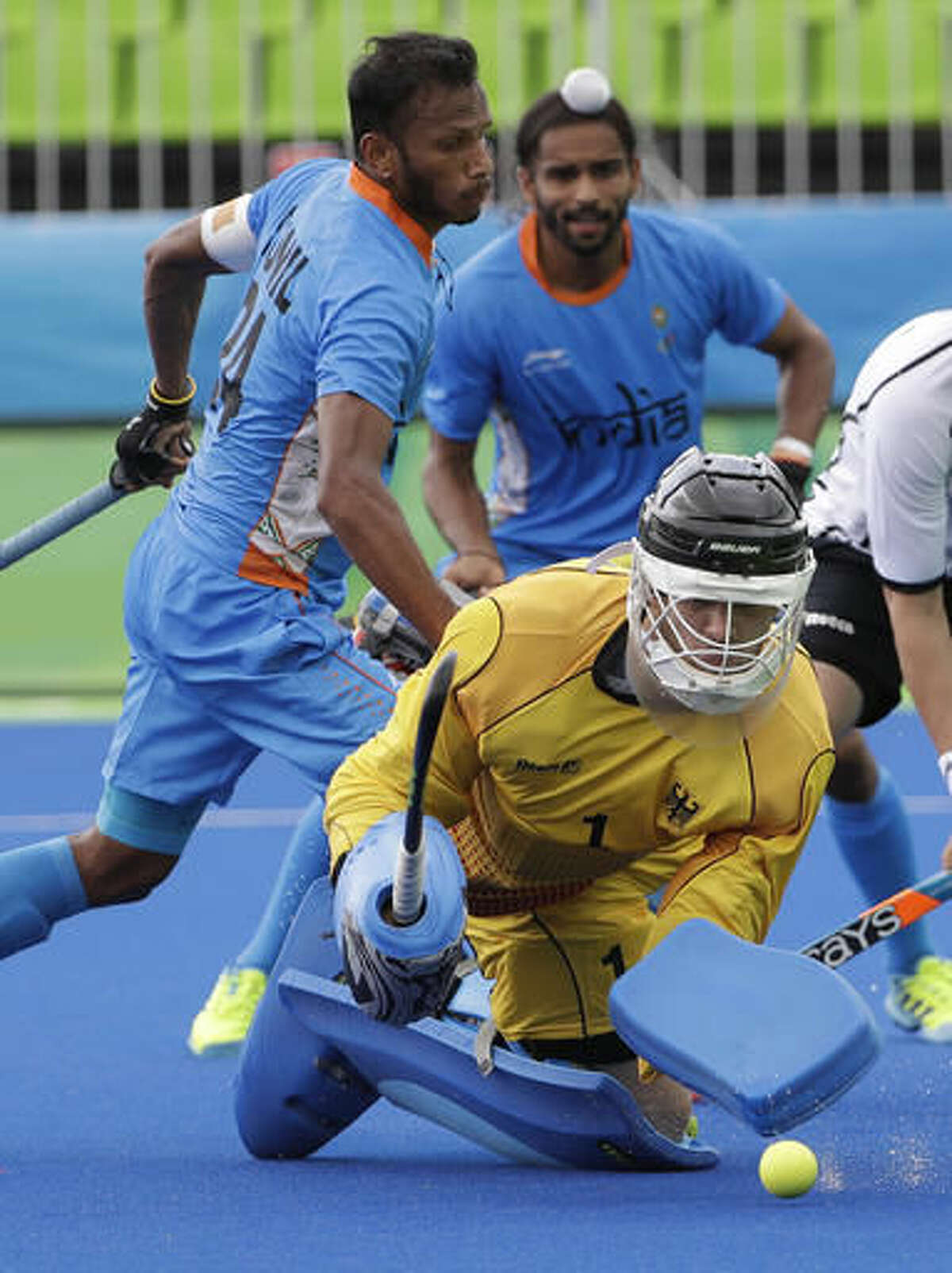 Germany's goalkeeper Nicolas Jacobi, foreground, saves the ball against India's Sunil Sowmarpet, center background, during a men's field hockey match at 2016 Summer Olympics in Rio de Janeiro, Brazil, Monday, Aug. 8, 2016. (AP Photo/Hussein Malla)