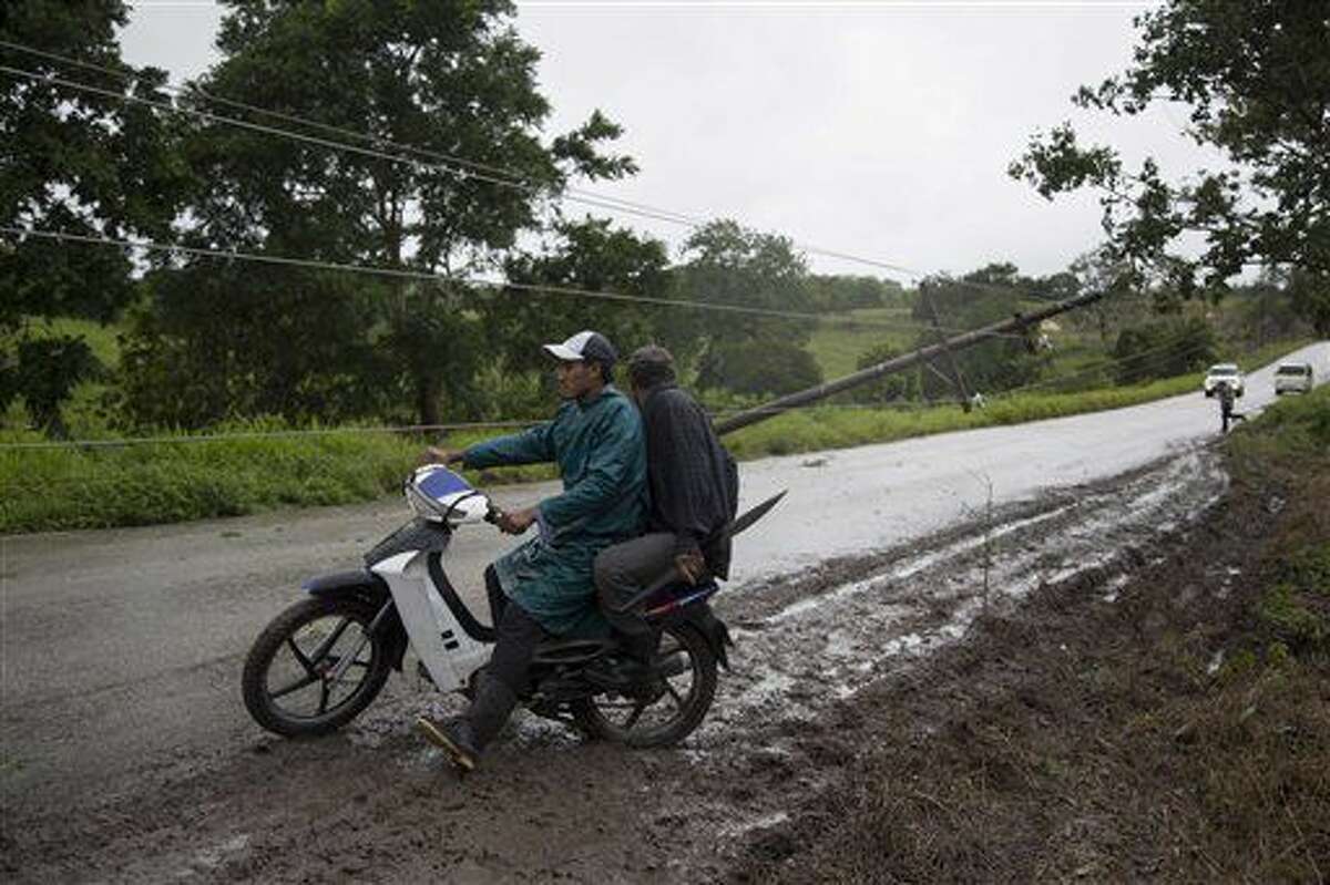 Un poste de electricidad derribado tras el paso del huracán Earl frena el tránsito en una carretera de Flores, en el norte de Guatemala, cerca de la frontera con Belice, el jueves 4 de agosto de 2016. (AP Foto/Luis Soto)