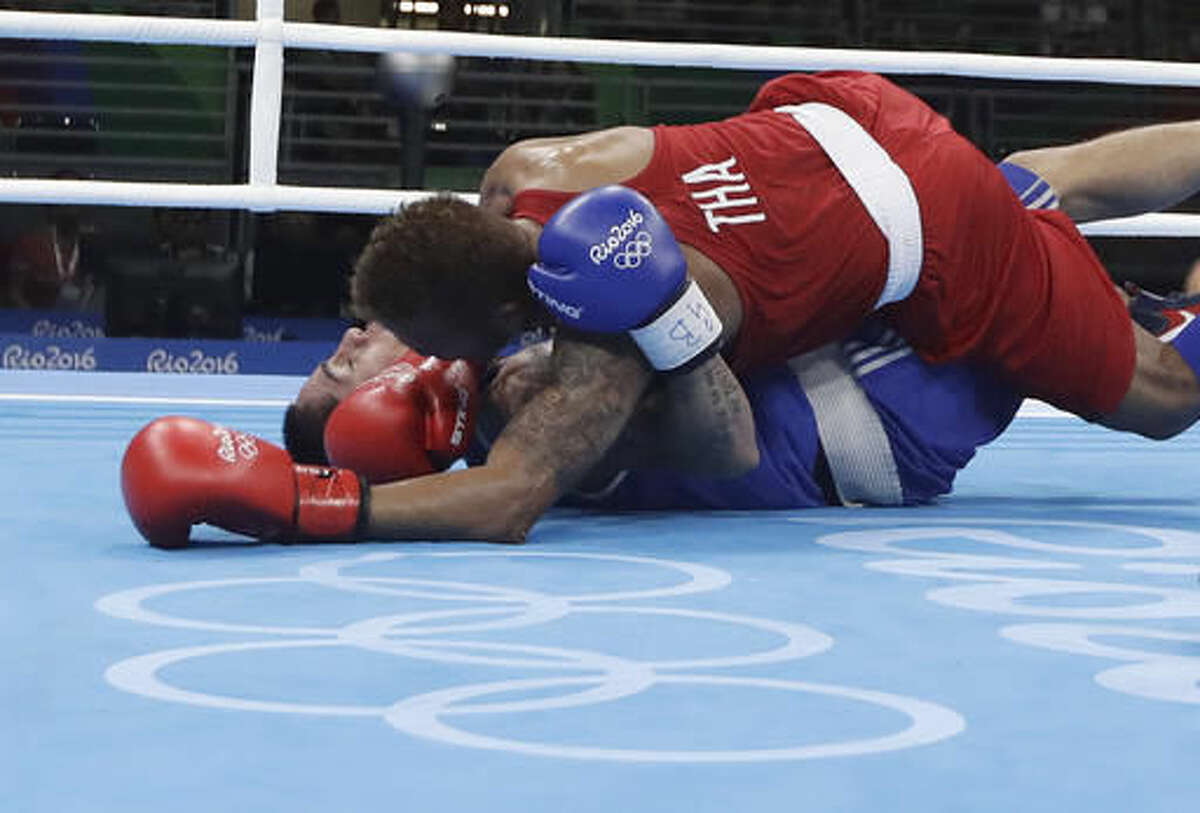 Thailand's Amnat Ruenroeng, top, and Argentina's Perrin Ignacio fall during a men's lightweight 60-kg preliminary boxing match at the 2016 Summer Olympics in Rio de Janeiro, Brazil, Sunday, Aug. 7, 2016. (AP Photo/Frank Franklin II)