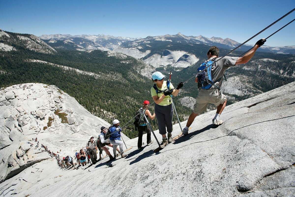 Climbers negotiate the steep pitch of the cable section of half Dome. The weekend summer crowds climbing Half Dome in Yosemite National Park have raised safety concerns among the climbers and park. Hundreds climb the precarious cable section every summer weekend day - many who are not prepared for the strenuous hike and 100 yard cable climb. Photos taken at Half Dome on Saturday, June 30, 2007. Photo by Michael Maloney / San Francisco Chronicle