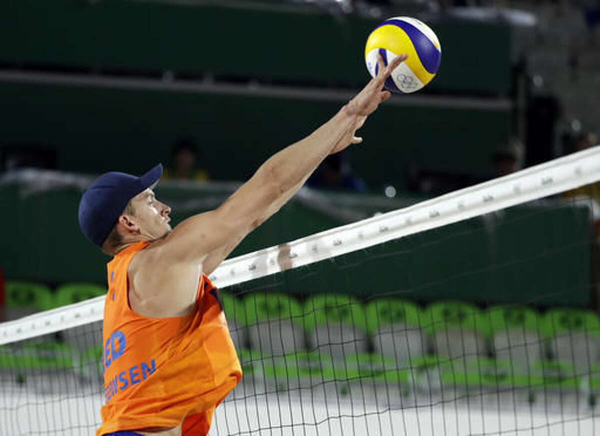 Netherlands' Robert Meeuwsen blocks a shot against Germany during a men's beach volleyball match at the 2016 Summer Olympics in Rio de Janeiro, Brazil, Monday, Aug. 8, 2016. (AP Photo/Marcio Jose Sanchez)