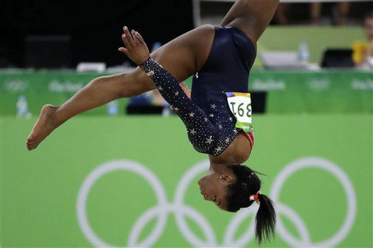 La estadounidense Simone Biles realiza un salto en su rutina de piso durante las eliminatorias de la gimnasia artística en los Juegos Olímpicos de Río de Janeiro, el domingo 7 de agosto de 2016 (AP Foto/Julio Cortez)