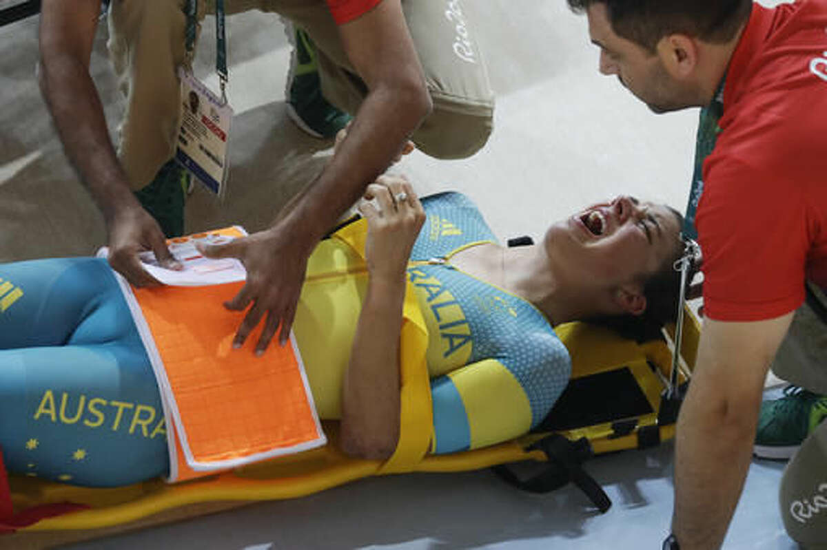 Melissa Hoskins of the Australian women's track cycling team is tended to after crashing during a training session inside the Rio Olympic Velodrome during the 2016 Olympic Games in Rio de Janeiro, Brazil, Monday, Aug. 8, 2016. (AP Photo/Pavel Golovkin)