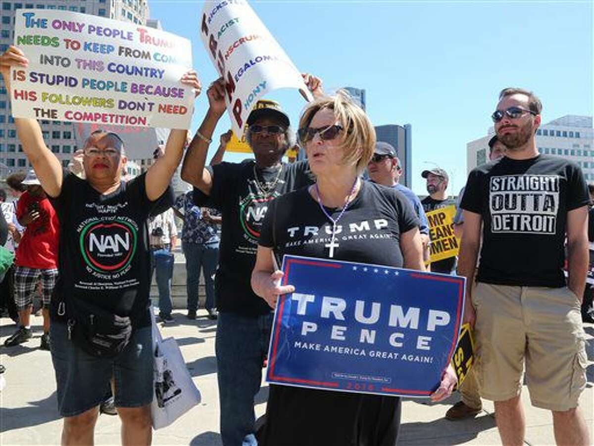 As Republican presidential candidate Donald Trump speaks inside at the Detroit Economic Club, protesters against the candidate and supporters for him demonstrate in downtown Detroit, Monday, Aug. 8, 2016. (Regina H. Boone/Detroit Free Press via AP)