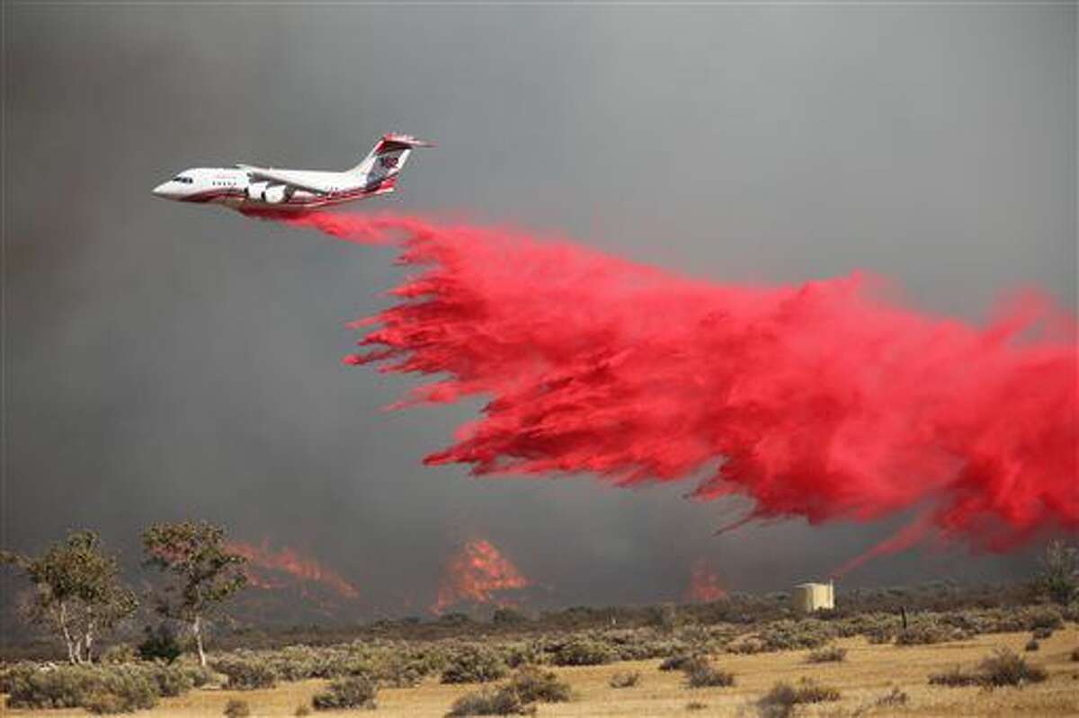 A tanker drops retardant on a wildfire fire east of Silverwood Lake Sunday, Aug. 7, 2016, in Crestline, Calif. Firefighters are battling a wildfire in Southern California that grew to more than 2 square miles in mere hours and forced the evacuation of homes near a reservoir. The fire is burning about 55 miles east of Los Angeles in a remote area near Silverwood Lake, a state recreation area, near the small mountain community of Crestline. (John M. Blodgett /The Inland Valley Daily Bulletin via AP)