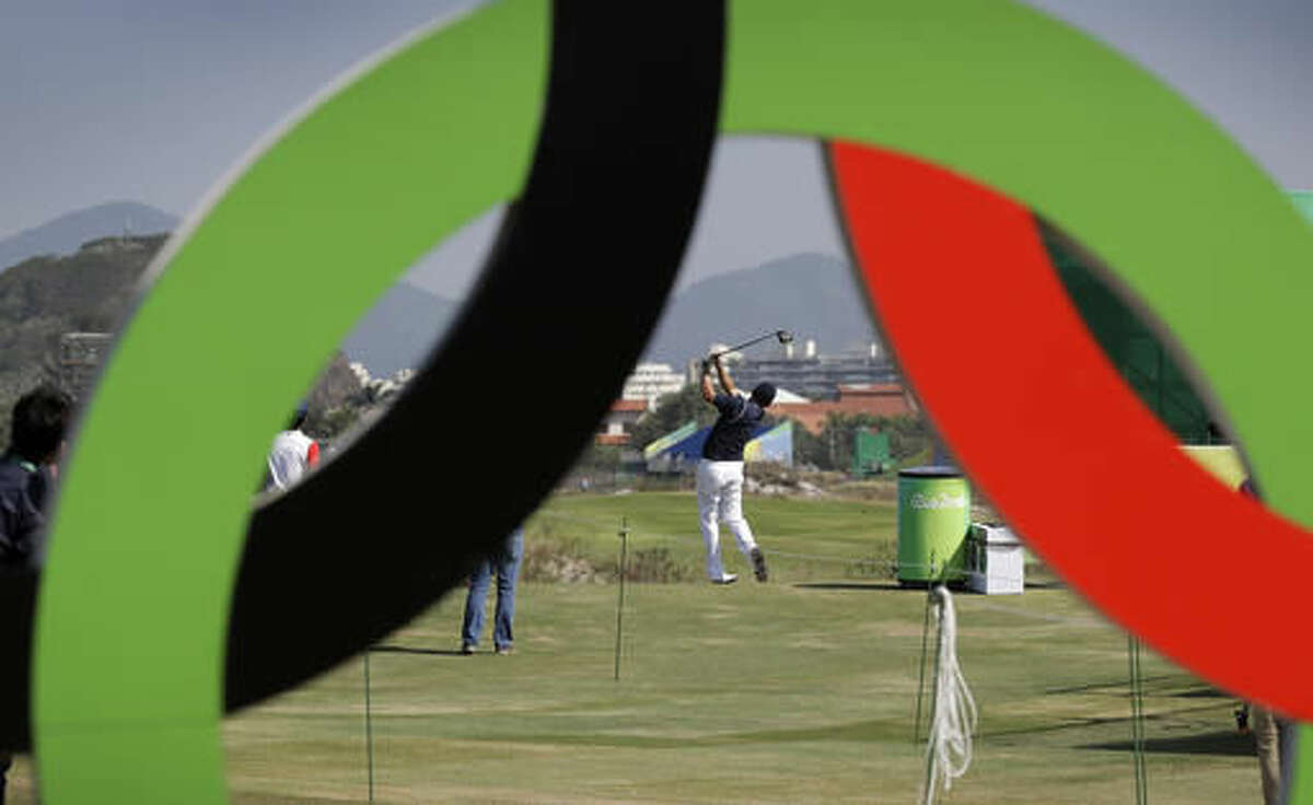Brazil's Adilson Da Silva, center, hits off the first tee during golf practice at the 2016 Summer Olympics in Rio de Janeiro, Brazil, Friday, Aug. 5, 2016. (AP Photo/Charlie Neibergall)