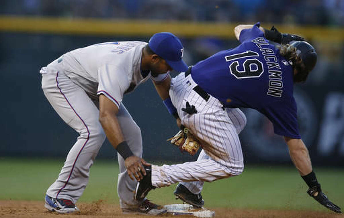 Texas Rangers shortstop Elvis Andrus, left, tags out Colorado Rockies' Charlie Blackmon as he tries to steal second base in the third inning of a baseball game Monday, Aug. 8, 2016 in Denver. Texas won 4-3. (AP Photo/David Zalubowski)