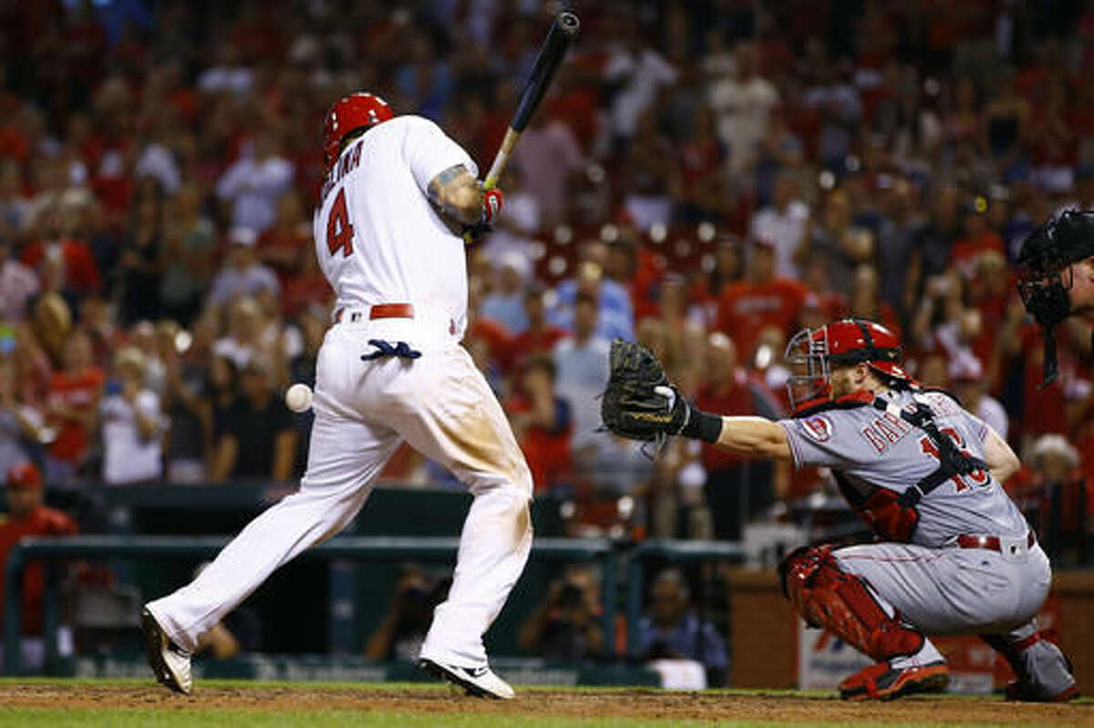 St. Louis Cardinals' Yadier Molina, left, is hit by a pitch with the bases loaded for a walk-off victory during the ninth inning of a baseball game against the Cincinnati Reds, Monday, Aug. 8, 2016, in St. Louis. The Cardinals won the game 5-4. (AP Photo/Billy Hurst)