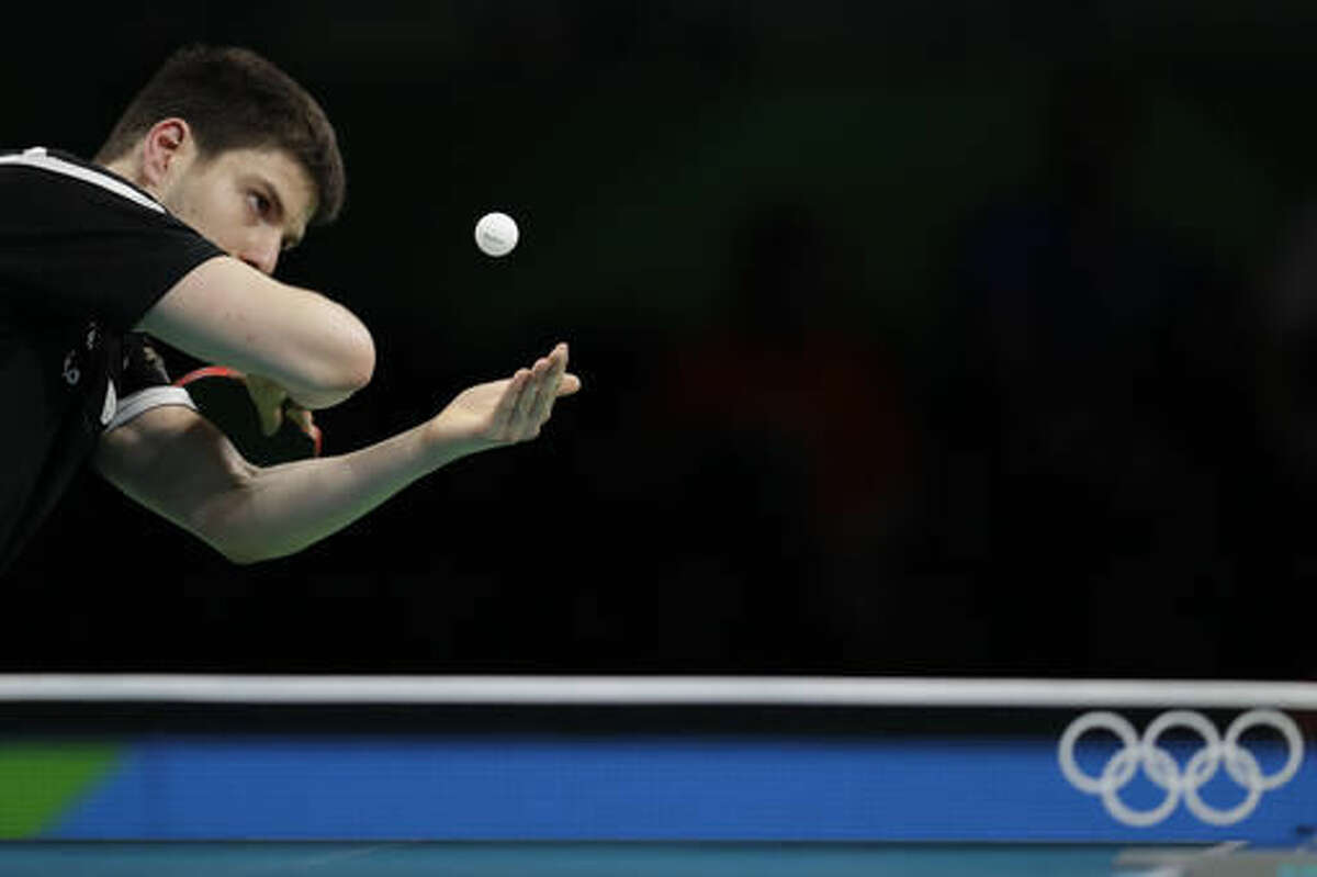 Dimitrij Ovtcharov of Germany eyes the ball as he is playing against Li Ping of Qatar during their table tennis match at the 2016 Summer Olympics in Rio de Janeiro, Brazil, Monday, Aug. 8, 2016.(AP Photo/Petros Giannakouris)