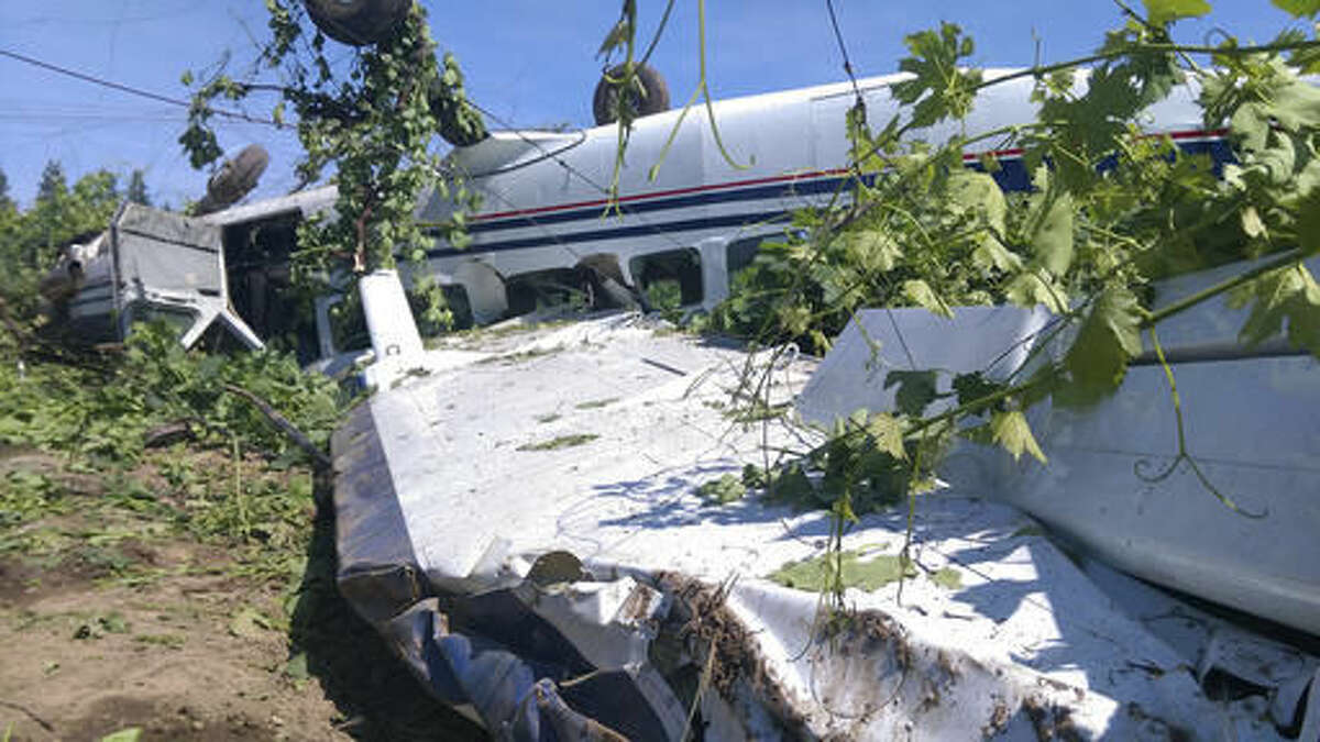 FILE - In a Thursday, May 12, 2016 file photo, a single-engine Cessna Caravan from the Lodi Parachute Center sits flipped over after an emergency landing in a vineyard near a home in rural San Joaquin County near Lodi, Calif., after a small plane taking 17 passengers skydiving made a hard landing and ended upside-down in a vineyard, leaving only the pilot with minor injuries. Two skydivers from the Parachute Center were killed Saturday, Aug. 6, 2016, during a tandem jump in northern California, authorities said Saturday. (Jason Anderson/The Record via AP, File)