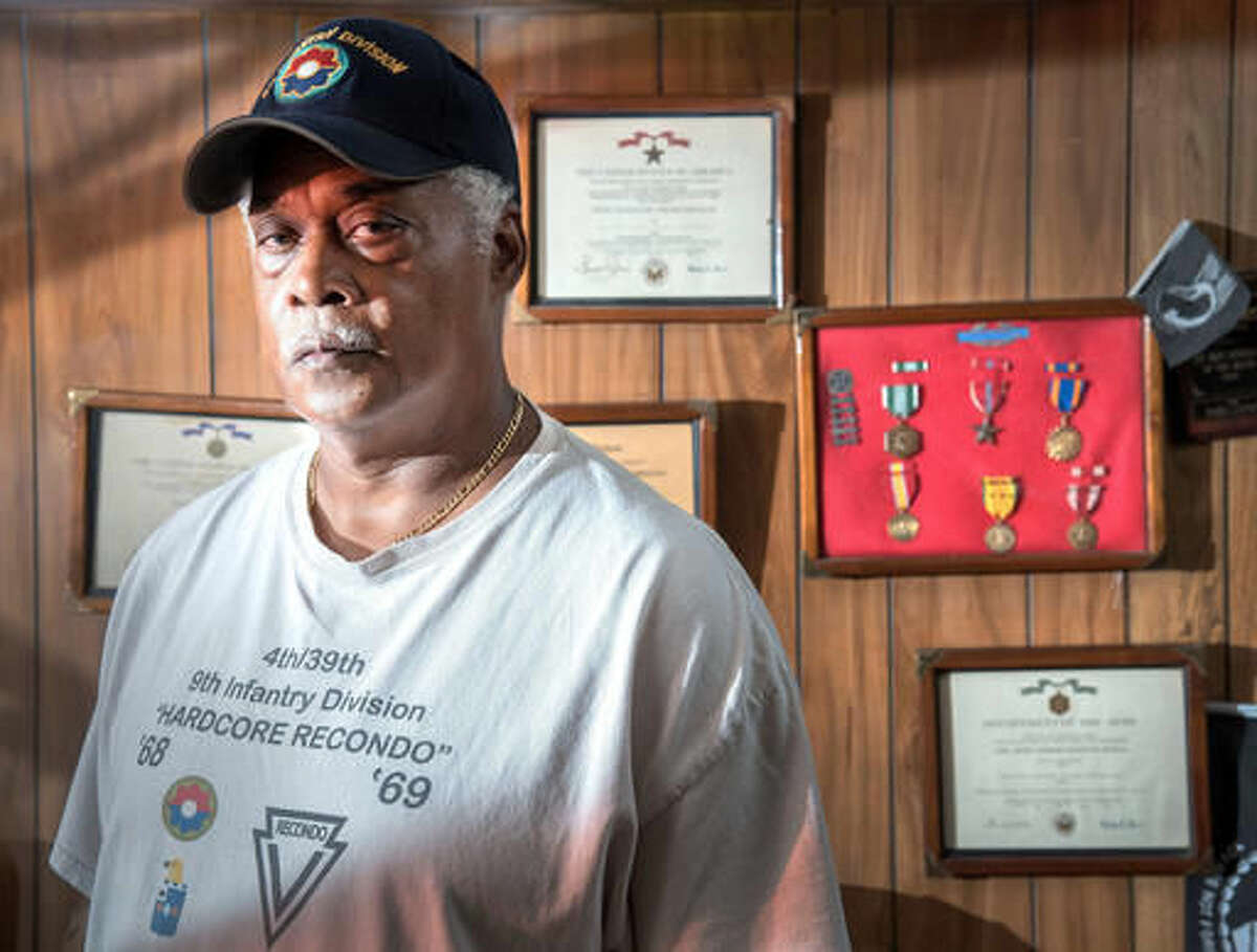 In this July 20, 2016 photo Robin Counce poses with his military service medals at his home in Champaign, Ill. Counce who carried a grenade launcher in Vietnam, survived a friendly fire attack while serving seven months in country. Among the medals he received in that time, almost one for every month, were the, Combat Infantry Badge, Army Commendation Medal and First Oak Leaf Cluster, Air Medal, Vietnam Service Medal, Vietnam Campaign Medal, Good Conduct Medal and National Defense Medal. (Rick Danzl/The News-Gazette via AP )
