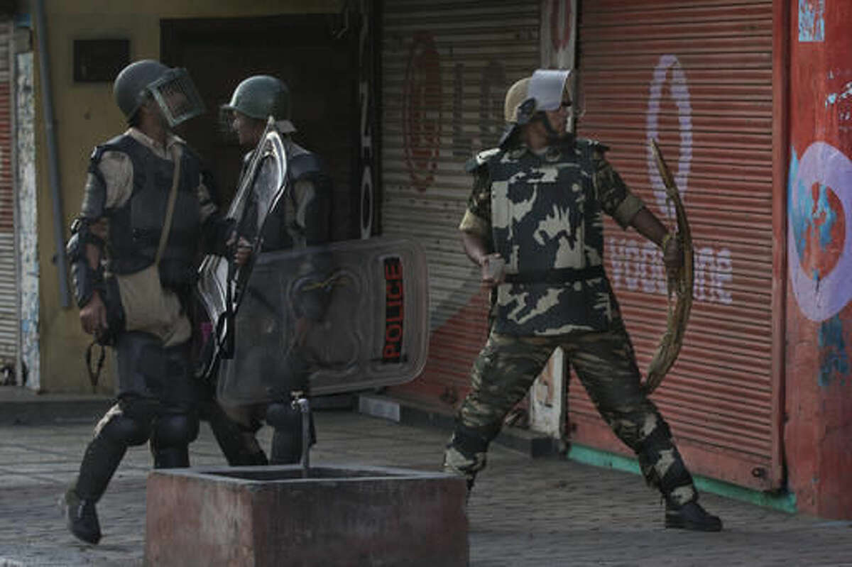 Indian paramilitary soldiers prepare to throw stones at Kashmiri Muslim protesters as they walk back towards their base camp after a day long curfew in Srinagar, Indian controlled Kashmir, Monday, Aug. 8, 2016. Kashmir has been under a security lockdown and curfew since the killing of a popular rebel commander on July 8 sparked some of the largest protests against Indian rule in recent years. (AP Photo/Dar Yasin)