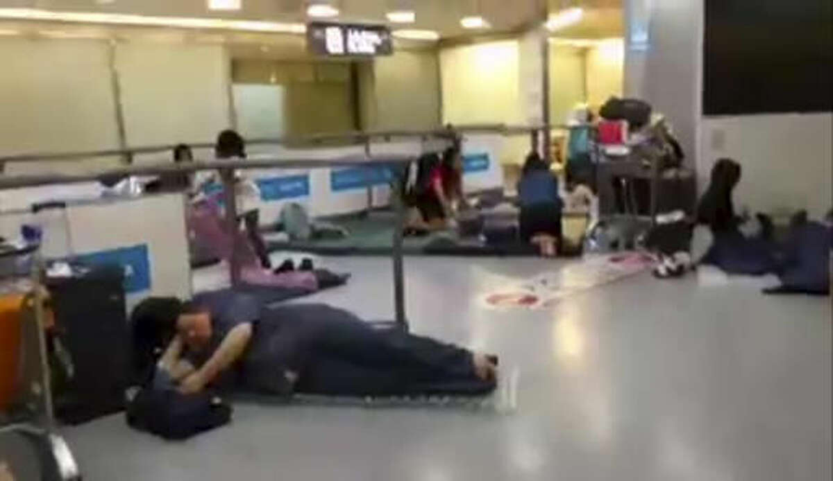 In this image made from video, stranded passengers lay on air mattresses at the Narita international airport in Narita outside Tokyo, early Tuesday, Aug. 9, 2016. Jeff Quigley, an American who lives in Japan and Indonesia, was one of thousands of passengers caught up in the worldwide Delta Air Lines shutdown. As day stretched into night, then overnight and the next morning, the 30-year-old venture capitalist posted live video updates on his Facebook page during what ended up being a nearly 20-hour delay at Narita airport outside Tokyo. (Jeff Quigley via AP)