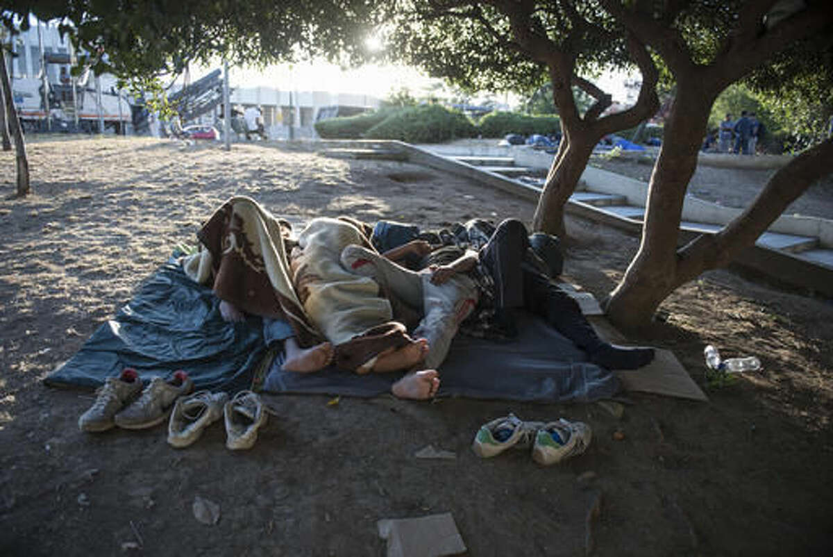 Migrants sleep in a park, at the northern Greek city of Thessaloniki, on Saturday, July 9, 2016. With Turkey in crisis and Europe’s borders closed, smugglers in northern Greece are looking forward to a profitable summer. Police say traffickers are using increasingly sophisticated methods _ with motorcycle spotters, “blind spot” maps in border surveillance, and even police informants to move refugees stuck here for months in limbo. (AP Photo/Giannis Papanikos)