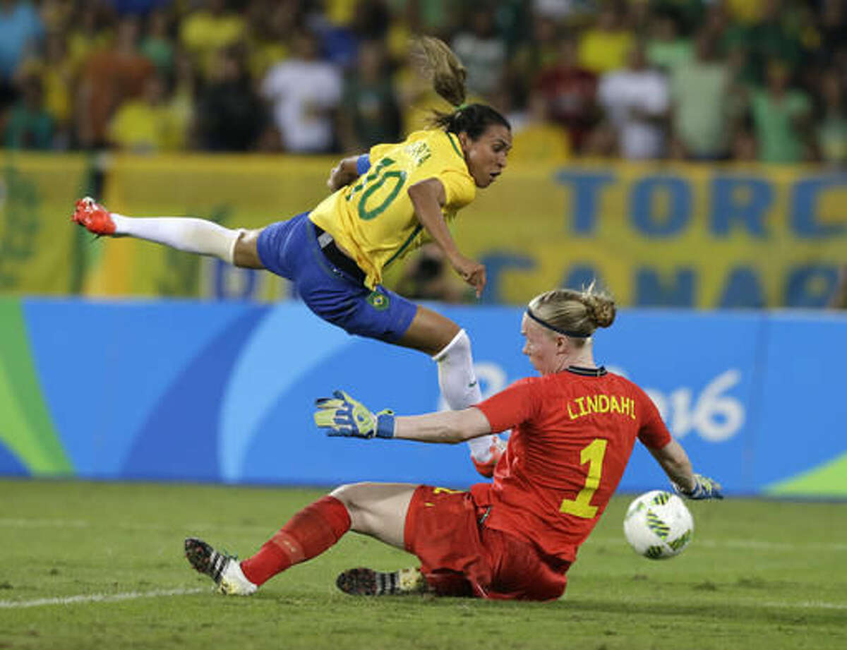Brazil's Marta, left, leaps over Sweden goalkeeper Hedvig Lindahl as she attempts a shot on goal during a group E match of the women's Olympic football tournament between Sweden and Brazil at the Rio Olympic Stadium in Rio De Janeiro, Brazil, Saturday, Aug. 6, 2016. Brazil won the game 5-1. (AP Photo/Leo Correa)