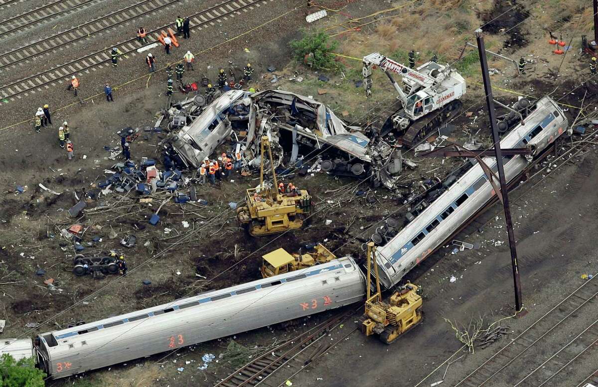 FILE- In this Wednesday, May 13, 2015 file photo, emergency personnel work at the scene of a derailment in Philadelphia of an Amtrak train headed to New York. Many commuter and freight railroads have made little progress installing safety technology designed to prevent deadly collisions and derailments despite a mandate from Congress, according to a government report released Wednesday, Aug. 17, 2016. (AP Photo/Patrick Semansky, File) ORG XMIT: WX110