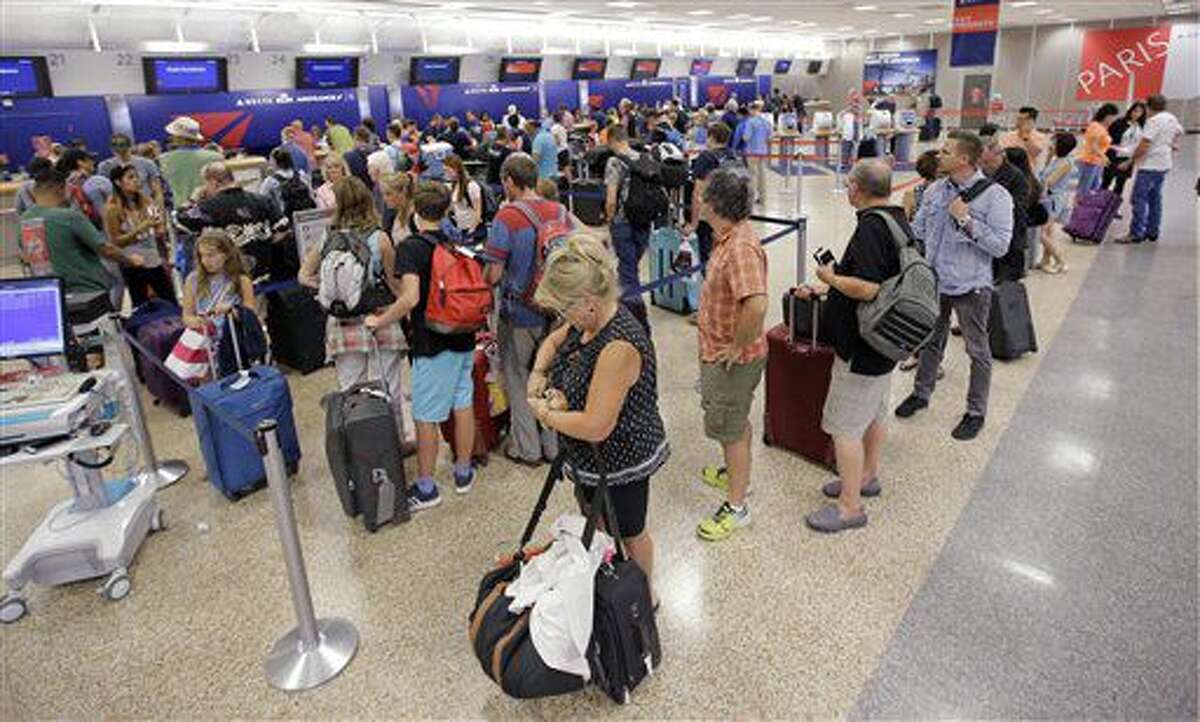 Pasajeros de la aerolínea Delta hacen fila tras la reanudación de los vuelos de la empresa luego de un fallo informático, el 8 de agosto de 2016, en Salt Lake City. (AP Foto/Rick Bowmer)