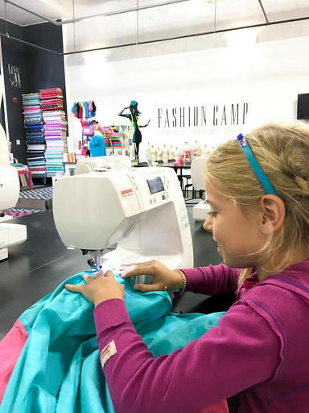 This photo provided by Fashion Camp - Create. Design. Sew., shows a young sewer going through the steps of designing, measuring and sewing her own creation at Fashion Camp - Create. Design. Sew. in Tuscon, Calif. Roughly 800 kids are attending camp this summer. (Fashion Camp - Create. Design. Sew. via AP)