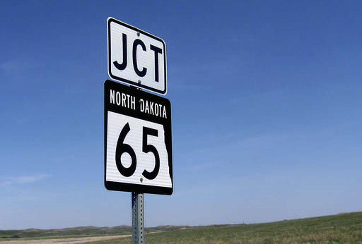 FILE - This May 2016 file photo provided by the North Dakota Department of Transportation shows a road sign with the rectangular outline of the state of North Dakota. North Dakota's Transportation Department was threatened with a civil rights complaint before it dropped its nearly century-old image of Sioux warrior Marcellus Red Tomahawk in favor of the outline of North Dakota on thousands of highway signs. Transportation Director Grant Levi said Tuesday, Aug. 9, 2016, the threat played no part in switching the signs. (North Dakota Transportation Department photo via AP, File)