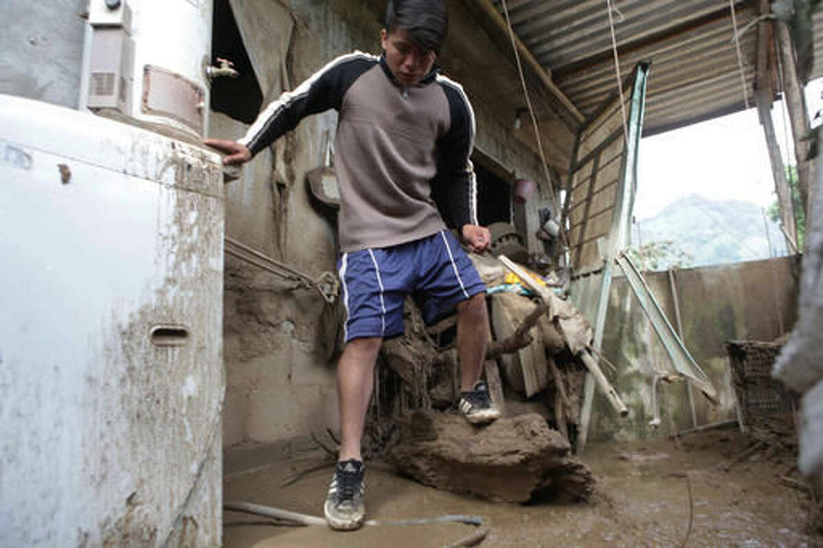 A resident inspects damage to his house affected by a mudslide in Xaltepec, Mexico, Monday, Aug. 8, 2016. Mountain communities in two Mexican states are recovering from weekend mudslides that killed dozens during heavy rains brought by remnants of Hurricane Earl. (AP Photo/Pablo Spencer)