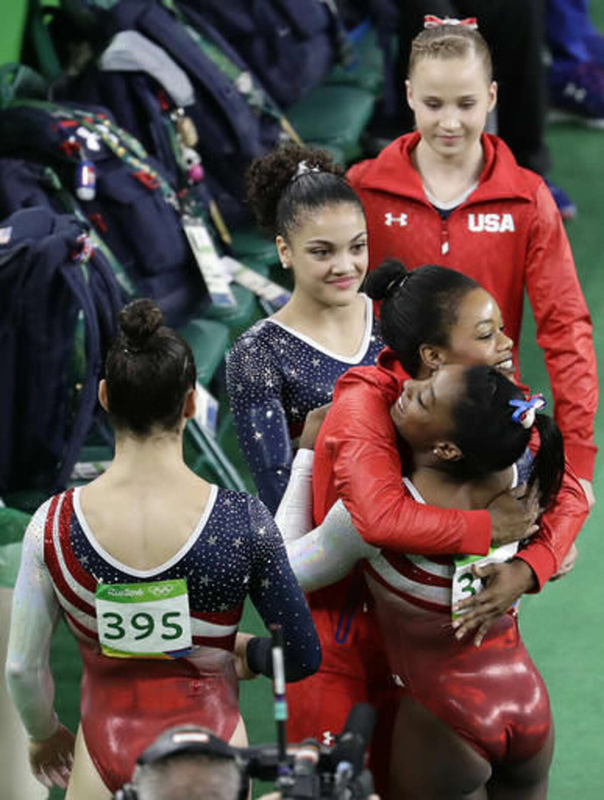 United States' Gabrielle Douglas, facing camera, hugs teammate Simone Biles after her performance on the vault during the artistic gymnastics women's team final at the 2016 Summer Olympics in Rio de Janeiro, Brazil, Tuesday, Aug. 9, 2016. (AP Photo/Dmitri Lovetsky)