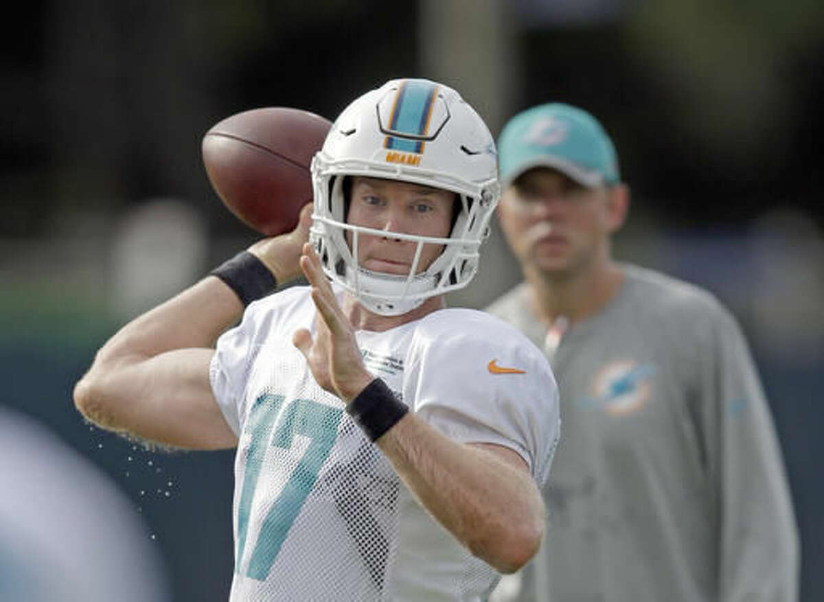 Miami Dolphins quarterback Ryan Tannehill prepares to throw a pass as assistant coach Bo Hardegree, right, watches, during practice at the NFL football teams training camp, Tuesday, Aug. 9, 2016, in Davie, Fla. (AP Photo/Alan Diaz)