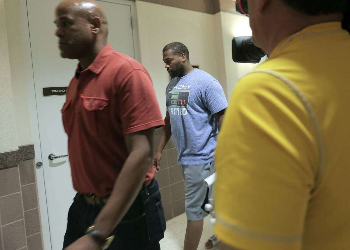 HPD Officer James Combs, center, is shown leaving the Fort Bend County Sheriff's Office on Wednesday. He was charged with intoxication manslaughter in a head-on crash.