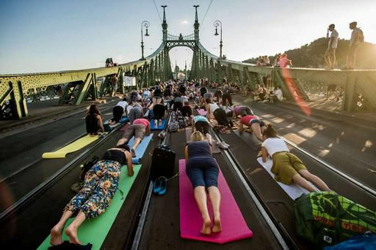 People perform yoga exercises on Freedom Bridge in downtown Budapest, Hungary, Tuesday, August 9, 2016. Yoga instructors held classes for over 600 practitioners on Budapest’s Freedom Bridge, which is closed for renovations, in an effort to popularize the discipline and practice it in a unique location. (Zoltan Balogh/MTI via AP)