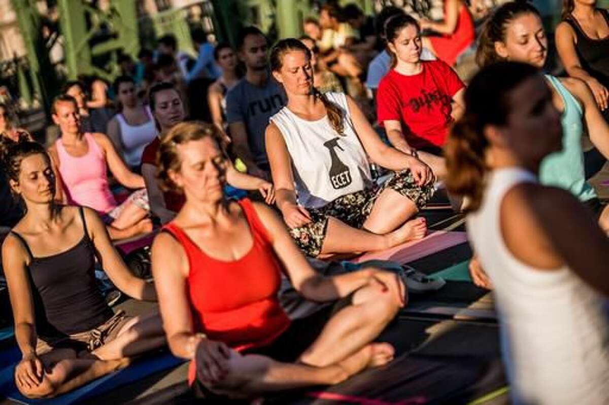 People perform yoga exercises on Freedom Bridge in downtown Budapest, Hungary, Tuesday, August 9, 2016. Yoga instructors held classes for over 600 practitioners on Budapest’s Freedom Bridge, which is closed for renovations, in an effort to popularize the discipline and practice it in a unique location. (Zoltan Balogh/MTI via AP)