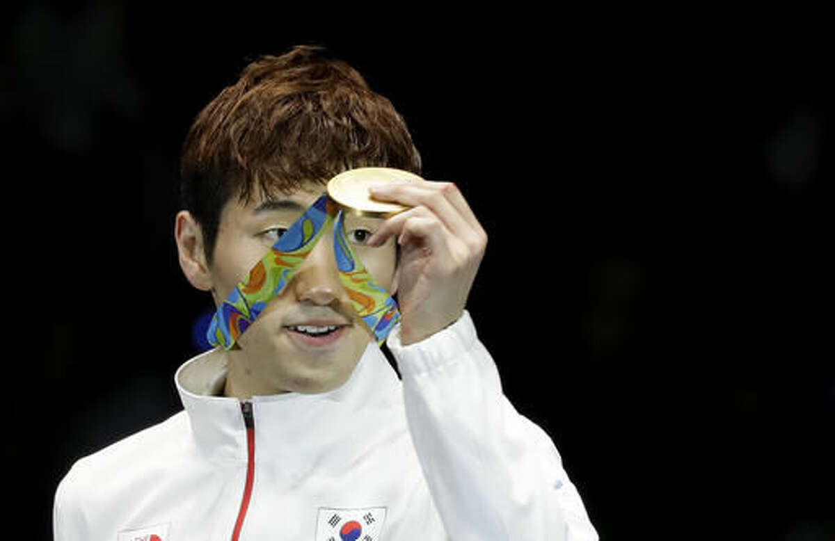 Park Sangyoung of South Korea shows the gold medal he won in a men's individual epee final at the 2016 Summer Olympics in Rio de Janeiro, Brazil, Tuesday, Aug. 9, 2016. (AP Photo/Andrew Medichini)