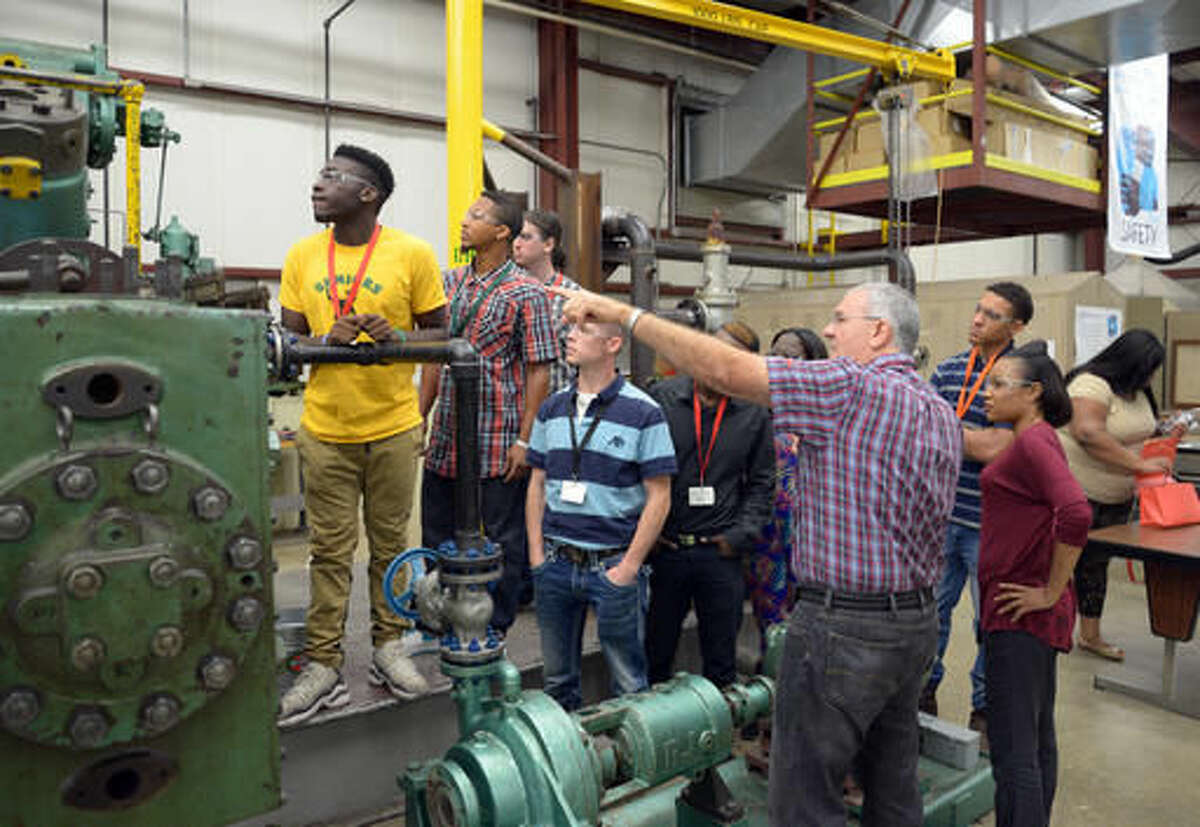 Mike Tucker with Eastman Chemical Co. talks to a group of pre-apprenticeship program students from Workforce Solutions about a compressor in Eastman's safety training facility during a tour Tuesday, Aug. 2, 2016, in Longview, Texas. (Les Hassell/The News-Journal via AP)