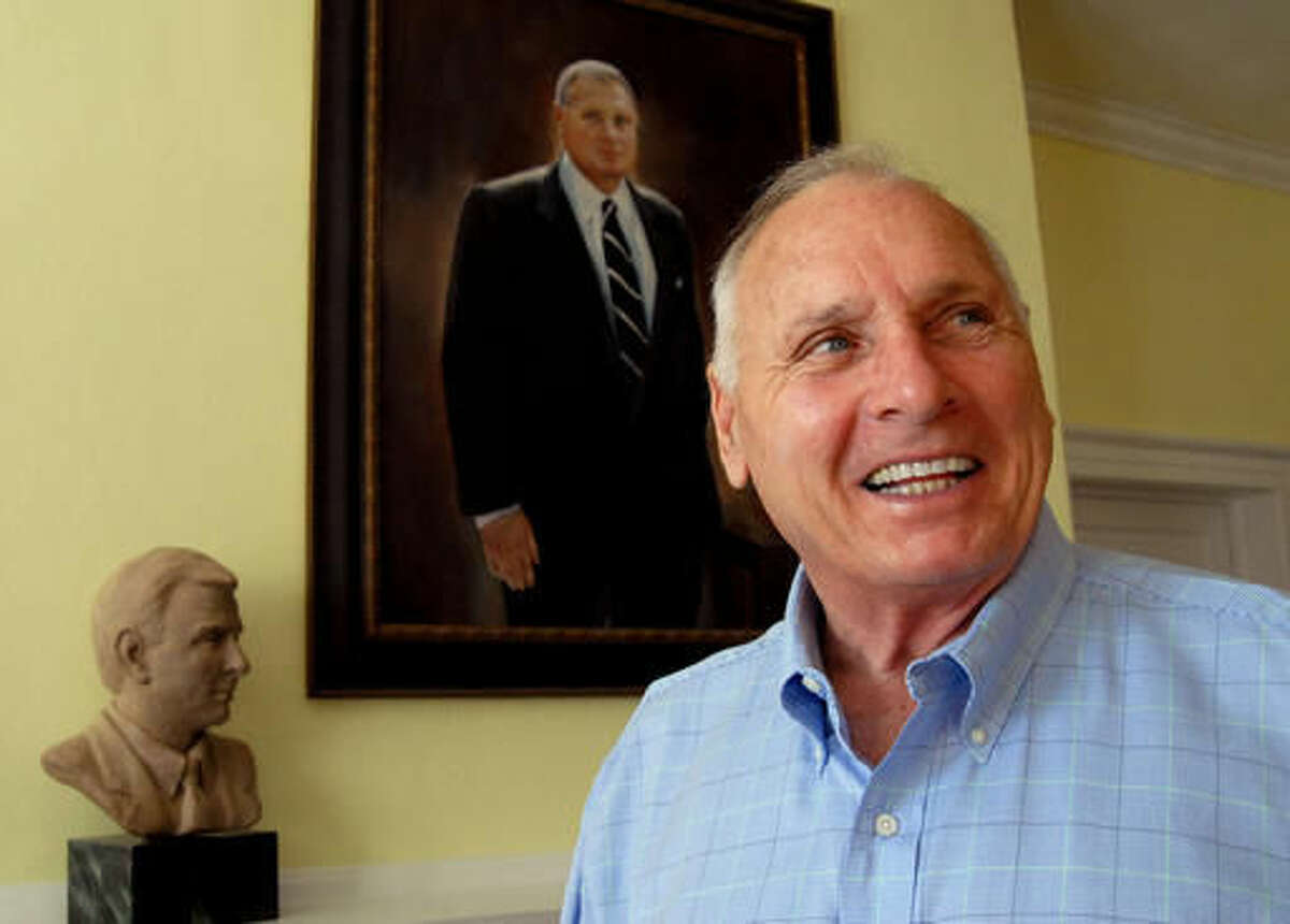FILE - In this Oct. 4, 2006, file photo, former college football coach Bill Dooley talks about his career as he stands in front of both a portrait and a bust of himself in the living room of his home in Wrightsville Beach, N.C. Former North Carolina, Virginia Tech and Wake Forest coach Bill Dooley has died at the age of 82. His wife, Marie, said Dooley died Tuesday, Aug. 9, 2016, of natural causes at their home in Wilmington. Dooley went a combined 162-125-5 in 26 seasons as a head coach with the Tar Heels, Hokies and Demon Deacons and took them to a combined 10 bowl games. AP Photo/Karen Tam, File)