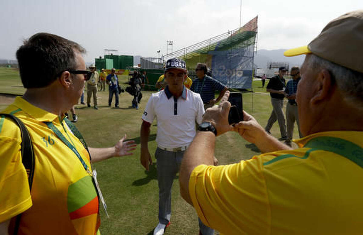 Volunteers greets Rickie Fowler, of the, United States, after a practice round for men's golf event at the 2016 Summer Olympics in Rio de Janeiro, Brazil, Tuesday, Aug. 9, 2016. (AP Photo/Chris Carlson)