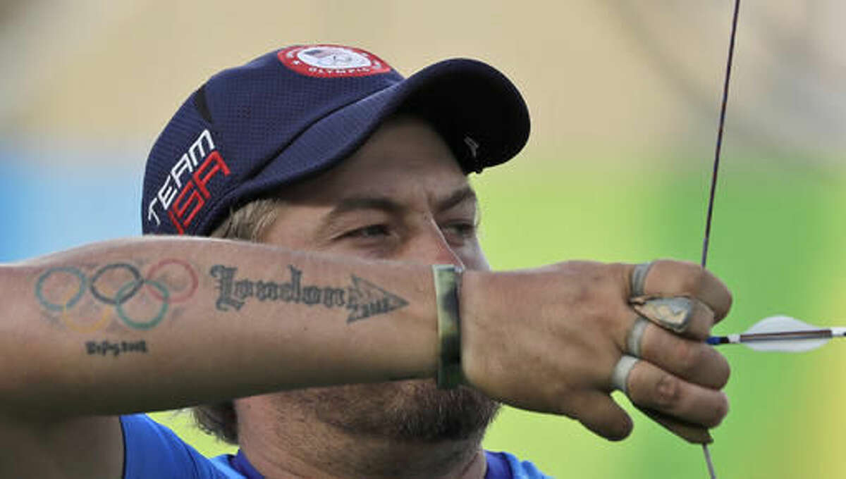 Brady Ellison of the United States, sports a tattoo with the Olympic rings as he releases his arrow during an elimination round of the individual archery competition at the Sambadrome venue during the 2016 Summer Olympics in Rio de Janeiro, Brazil, Tuesday, Aug. 9, 2016. (AP Photo/Alessandra Tarantino)