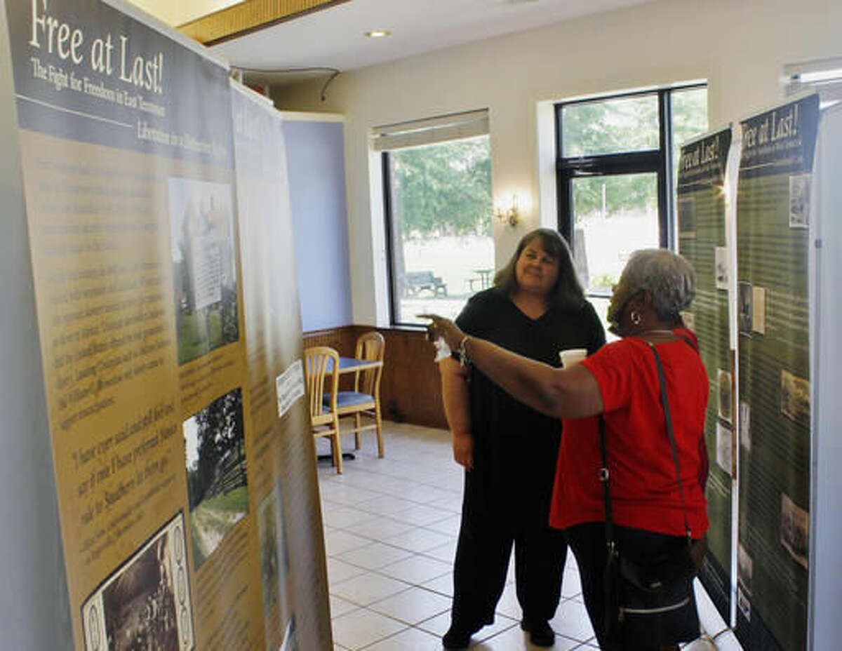 In this Monday, Aug. 1, 2016, photo, West Tennessee Delta Heritage Center Director Sonia Outlaw-Clark, center, discusses the "Free at Last!" exhibit with Renee Burley-Anderson at the heritage center in Brownsville, Tenn. (Emily Littleton/The Jackson Sun via AP)