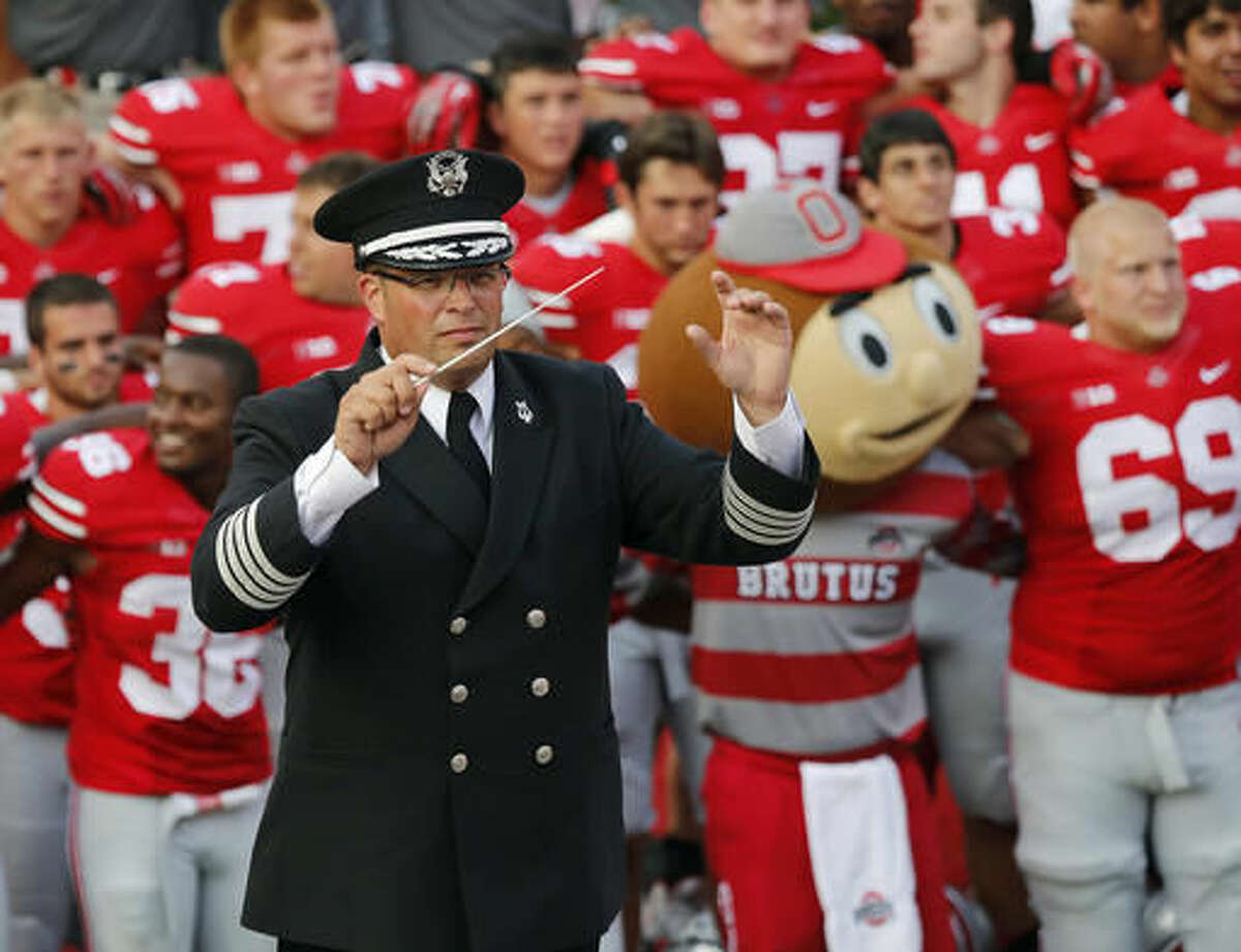 FILE - In this Sept. 7, 2013, file photo, Ohio State University marching band director Jonathan Waters leads the band in "Carmen Ohio" following an NCAA college football game at Ohio Stadium in Columbus, Ohio. Two years after Ohio State University fired Waters for failing to rein in a “sexualized culture,” a lawsuit against the university continues even as the ex-director has moved on and the band has a new leader. (Adam Cairns/The Columbus Dispatch via AP, File)