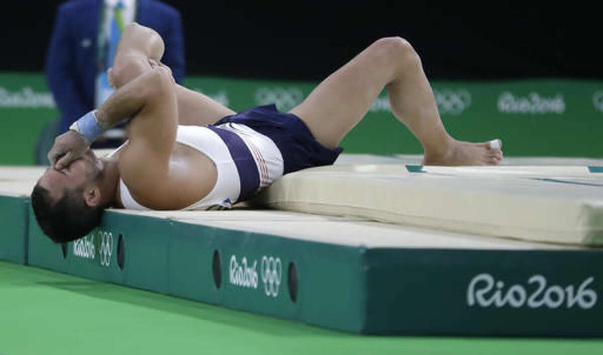 France's Samir Ait Said holds his leg after injuring it while performing on the vault during the artistic gymnastics men's qualification at the 2016 Summer Olympics in Rio de Janeiro, Brazil, Saturday, Aug. 6, 2016. (AP Photo/Julio Cortez)