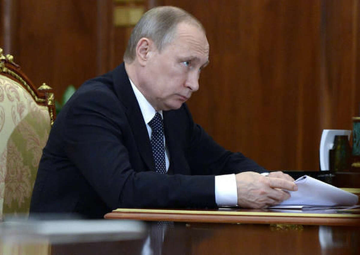 Russian President Vladimir Putin holds papers during a meeting in Moscow's Kremlin on Friday, Aug. 5, 2016. (Alexei Nikolsky/Sputnik, Kremlin Pool Photo via AP)