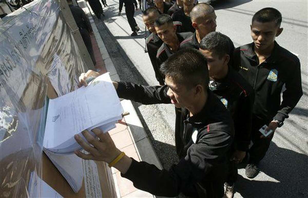 Un grupo de soldados tailandeses hacen fila para comprobar sus nombres antes de votar en un referendum sobre una nueva constitución, en Bangkok, Tailandia, el 7 de agosto de 2016. (AP Foto/Sakchai Lalit)