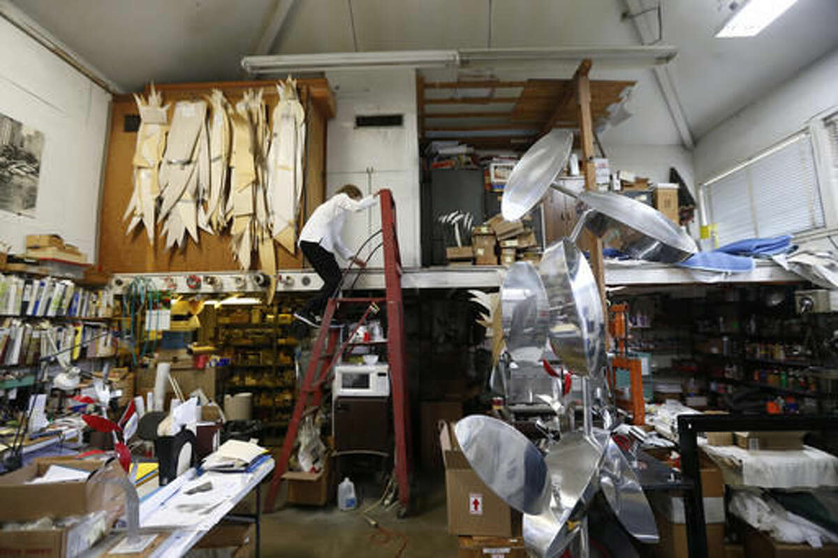 Sculptor Lin Emery climbs up a ladder to the loft in her studio in New Orleans, Tuesday, June 28, 2016. Her kinetic sculptures, moved by magnets, water, or wind, are in museum and private collections around the U.S., in Europe and the Far East. (AP Photo/Gerald Herbert)
